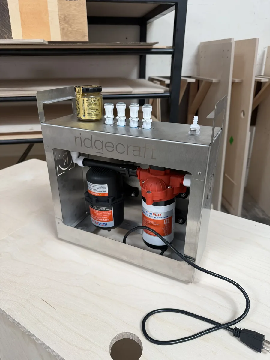 The Backbone on the bench: the pump and accumulator inside its brushed stainless enclosure