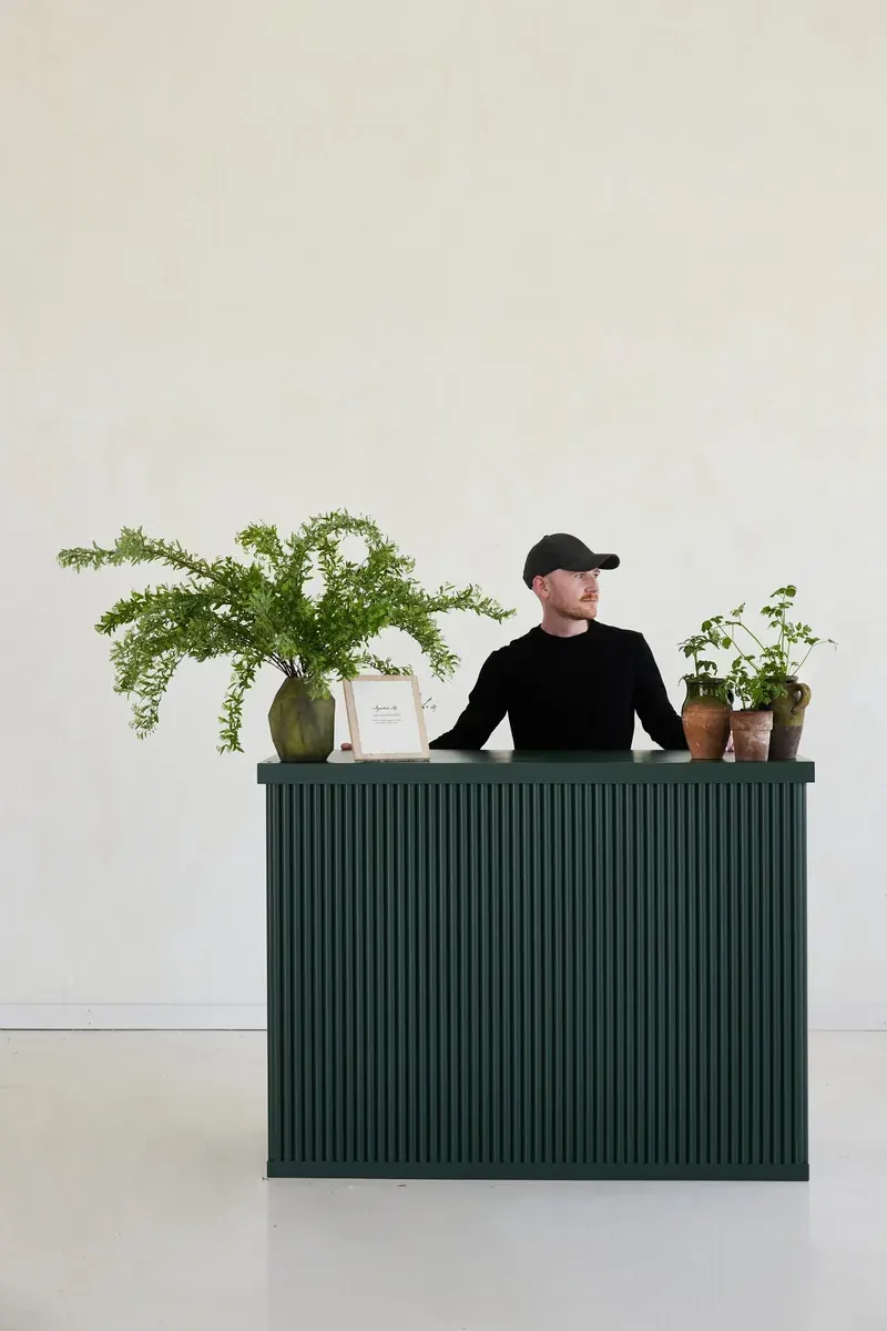 A RidgeCraft mobile bar with a fluted front painted forest green