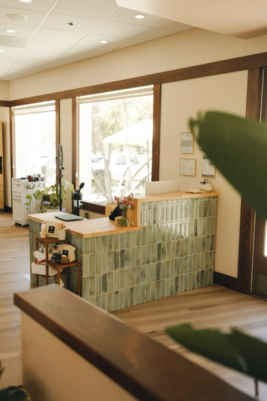 A green tiled reception counter with a wood top